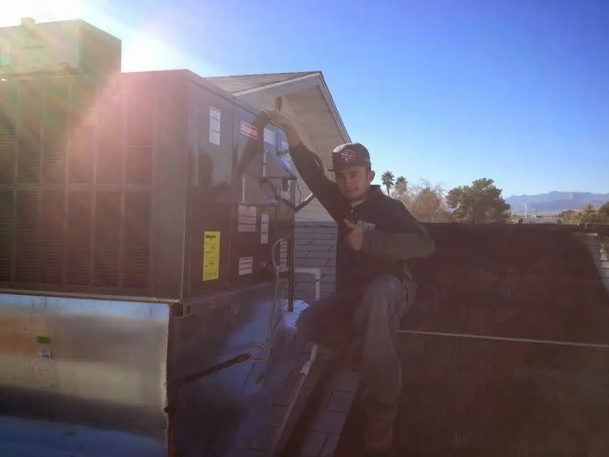 HVAC technician performing HVAC Inspection on a rooftop unit in Marianna